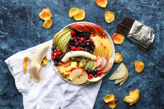 Prato de comida cheio de frutas cortadas.