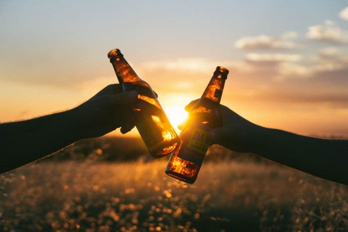 Duas pessoas brindando com cerveja