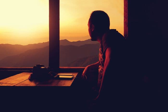homem vendo o sol nascer pela janela