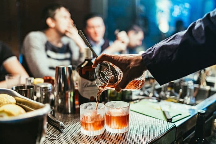 homem servindo bebidas em bar