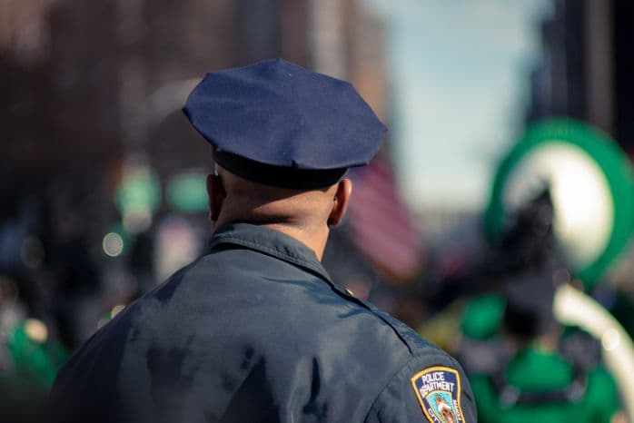 Policial de costas para a imagem