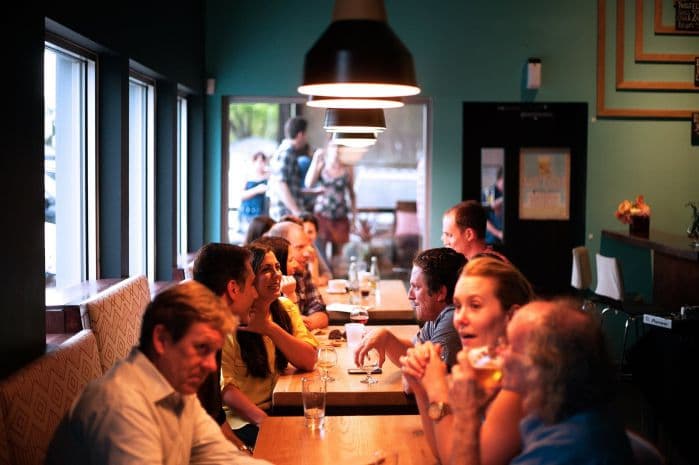 pessoas em um bar bebendo e comendo