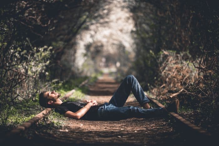 homem dormindo confortavelmente no chão ao ar livre