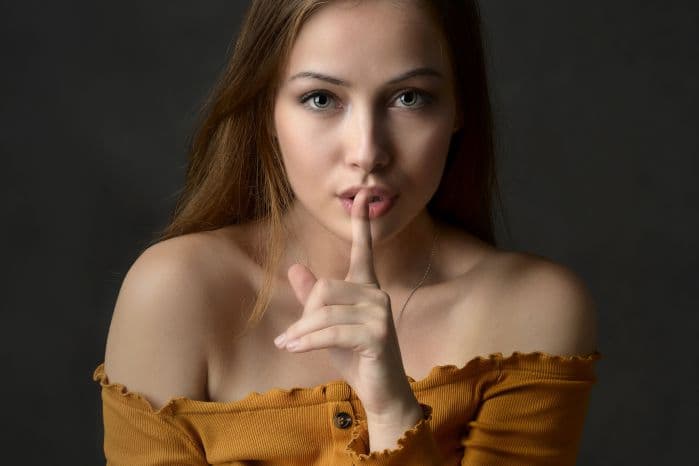 mulher fazendo sinal de silêncio