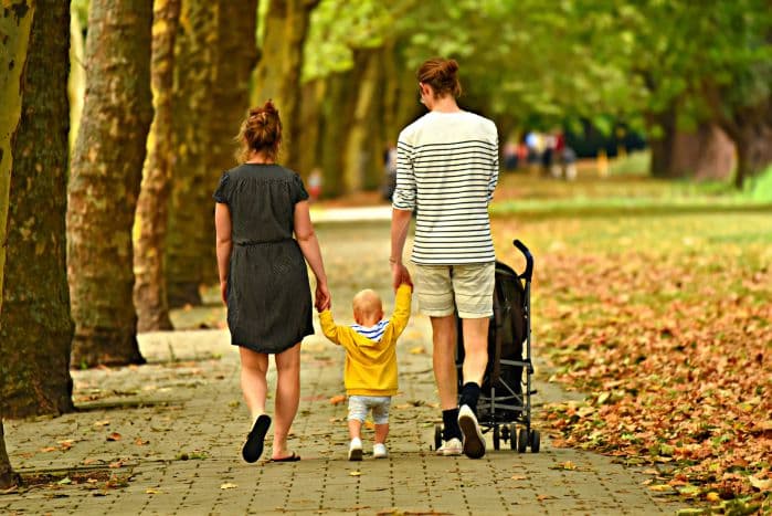 Pai mãe e filho caminhando em parque